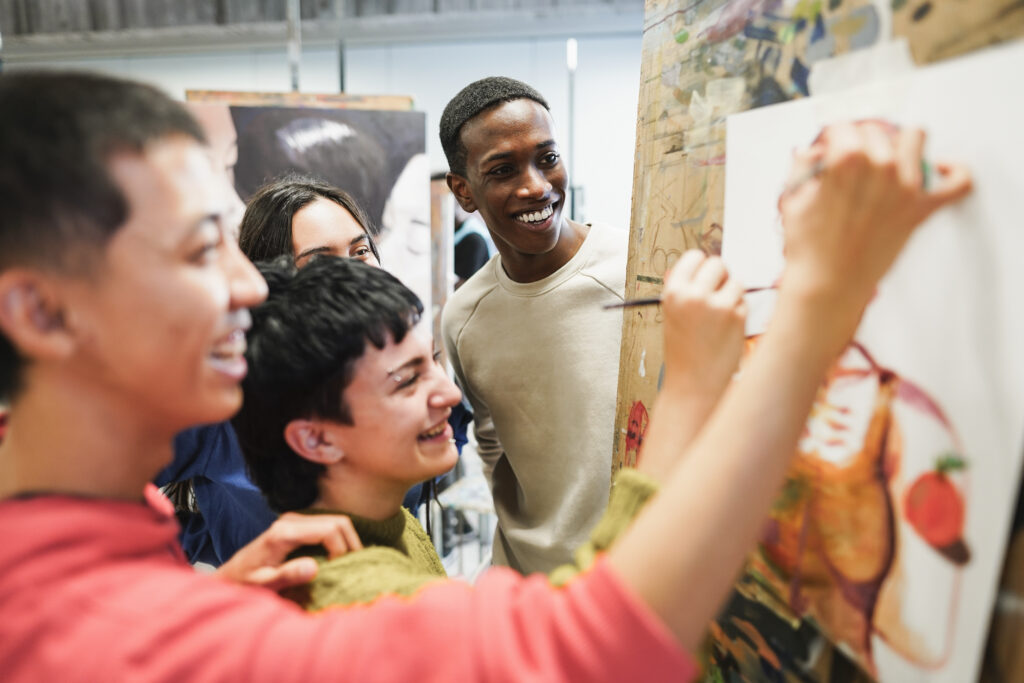 a group of young people around an easel